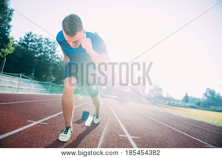 Sprinter leaving starting blocks on the running track. Explosive start