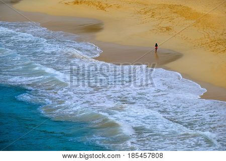 Bautiful beach rolling ocean waves and girl walking