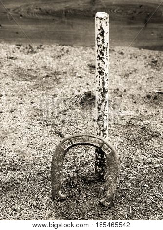 A Horseshoe leaning against the post. Black and White.