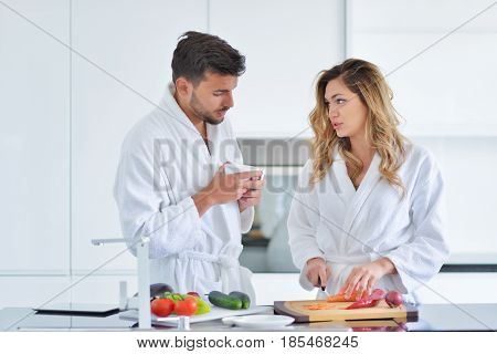 Happy couple cooking breakfast together in the kitchen.