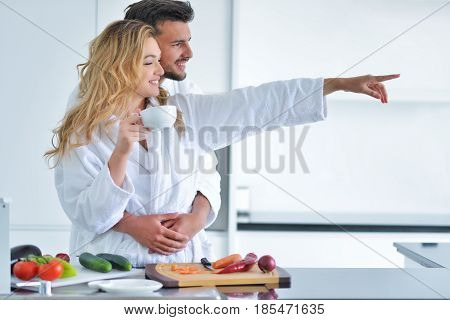 Happy couple cooking breakfast together in the kitchen.