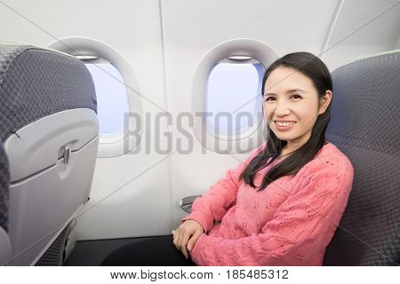 Middle aged woman smie happily in the airplane