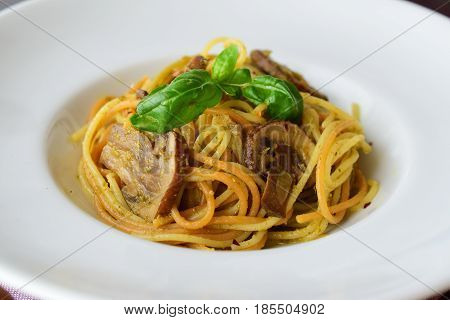 Pasta with mushroom.s and pesto sauce in a white plate on abstract bckground. Italian lifestyle. Healthy eating concept