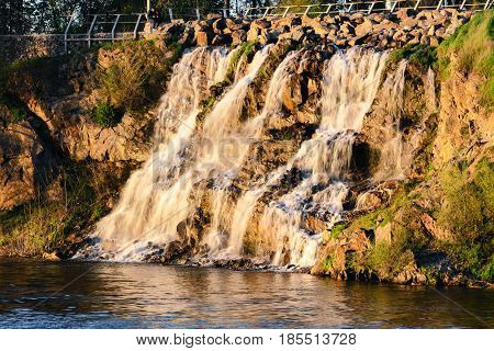 Beautiful waterfall at sunset in the rays of the setting sun. Dnepropetrovsk Ukraine