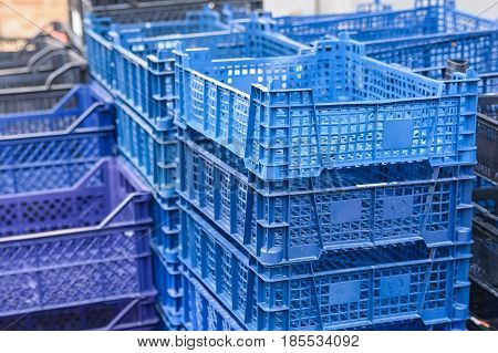 Close up pile of blue and violet plastic boxes outside