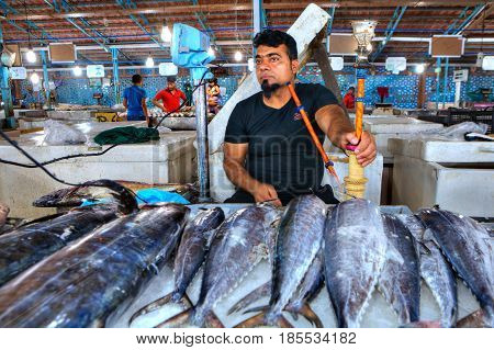 Bandar Abbas Hormozgan Province Iran - 15 april 2017: Fresh tuna lies on the ice in the fish market one adult man seller smokes a hookah.