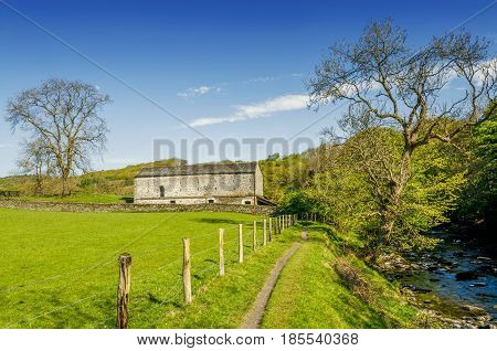 An isolated barn set in green English countyside.