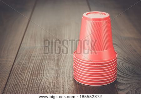 disposable plastic cups. red plastic cups on the wooden table. party plastic cups. stack of plastic cups