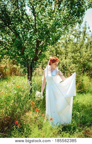 Young Beautiful Blonde Woman In Blooming Garden. Bride.