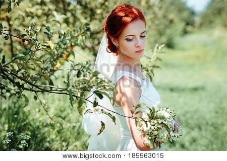Young Beautiful Blonde Woman In Blooming Garden. Bride.