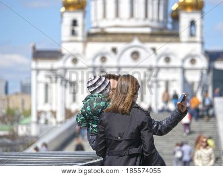 Moscow, Russia - May, 7, 2017: couple with a child makes selfie on Red Square in Moscow