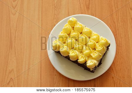 cream decorate rose flower topping chocolate cake on dish
