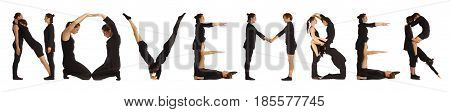 Black dressed people forming word NOVEMBER on white background