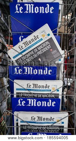 PARIS FRANCE - MAY 9 2017: Pov buying Le Monde with President's Challenges title newspaper front page with the picture of the newly elected French president Emmanuel Macron after the second round French Presidential election