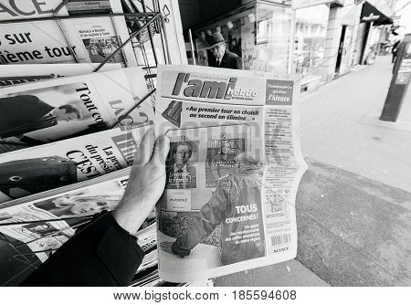 PARIS FRANCE - MAY 9 2017: Pov buying L'Ami Hebdo newspaper front page picture of the newly elected French president Emmanuel Macron second round French Presidential election