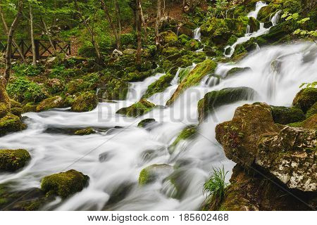 River water falling over mossy rocks in springtime, close up