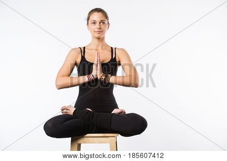 Sporty beautiful young woman sitting in Gomukhasana, Cowface pose, yin yoga Shoelace posture, asana for stretching hips and thighs, studio full length shot on white background, front view, isolated.