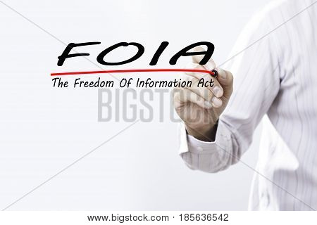 Businessman hand writing FOIA (The Freedom of Information Act) with red marker on transparent wipe board business concept.