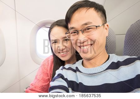 couple selfie and smile happily in airplane