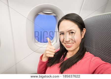 Middle aged women smie and selfie in the airplane