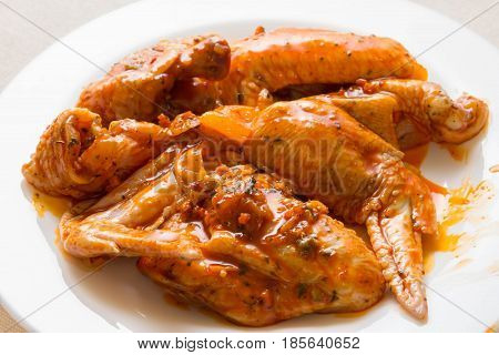 Raw chicken wings in marinade. The concept of cooking.