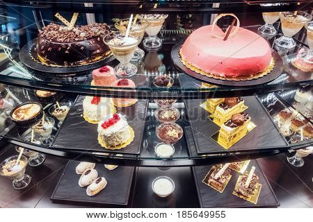Different desserts on bakery shop-window. Sweets and cakes for every taste