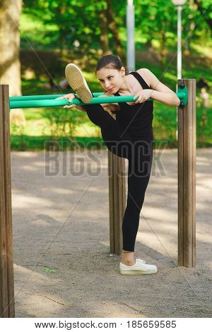 A girl in a park on a sports ground is engaged in gymnastics, training