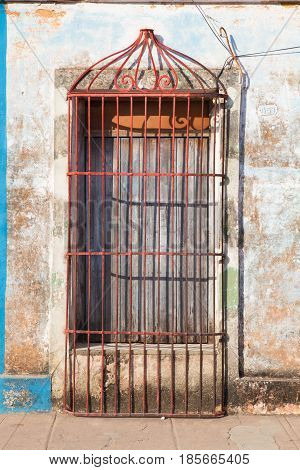 Typical colonial building with door iron grate in Trinidad Cuba