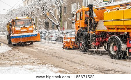 snow plough making shovelling roads in european city during winter storm