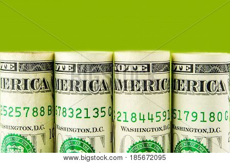 american dollar banknotes row on green background in a form of rolls