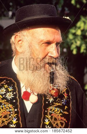Man Smoking A Pipe Dressed In Traditional Swiss Costume