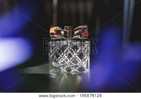 stylish bottle of female perfume over blue
