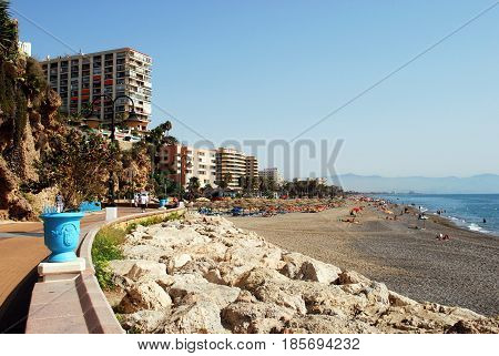 TORREMOLINOS, SPAIN - SEPTEMBER 3, 2008 - Tourists relaxing on the beach and promenade with hotels and apartments to the left Torremolinos Malaga Province Andalusia Spain Western Europe, September 3, 2008.