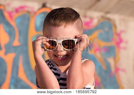 smiling little boy in sailor stripes singlet on graffiti background