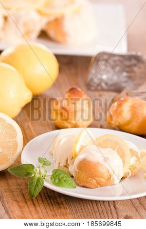 Lemon Profiteroles with custard cream on white dish.