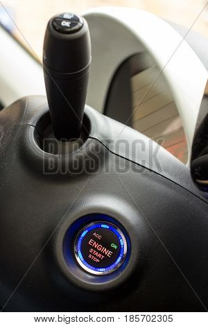 Start stop key into the lock of ignition of the car. Focused on button..