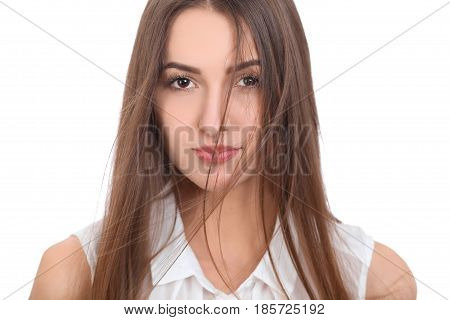 Beautiful brunette woman in a white blouse and a light wind blew her hair . Isolated background.