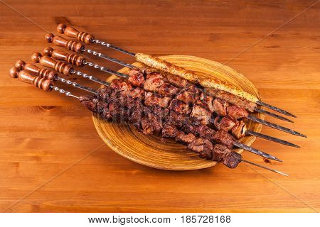 set shashlik. shish kebab on iron skewers on wooden background