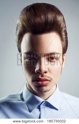 Portrait of young man with retro classic pompadour hairstyle. studio shot. looking at camera.