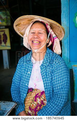 MINGUN,MYANMAR - MARC 6, 2017: Burmese old woman with hat and thanaka on their face in Mingun on March 6, 2017, Myanmar. Thanaka is a yellowish-white cosmetic paste made from ground 