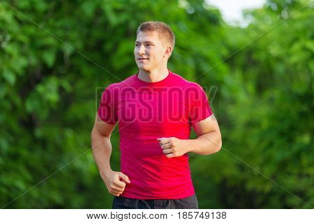 Athlete runner sprinting running to success. Fit male fitness sprinter training in sprint with determination and strength. Handsome athletic man working out outside on blue sky