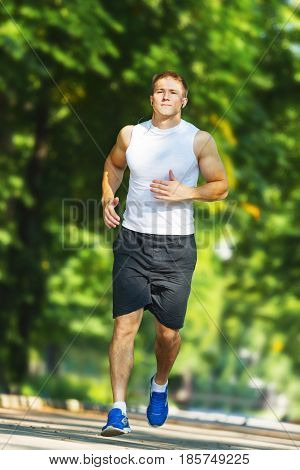 Triathlon running man. Triathlete runner training on Hawaii for ironman. Male athlete running in red compression clothing, shorts and top on volcano on Big Island, Hawaii