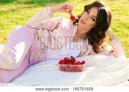 Beautiful Girl With Dark Hair Relaxing At Summer Picknic, Eating Strawberries