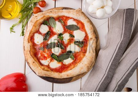 Whole neapolitan pizza served on wooden board