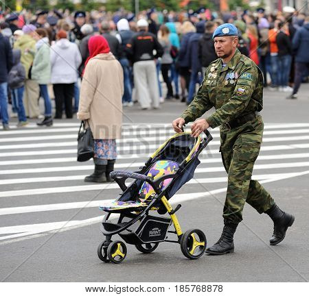Orel Russia - May 9 2017: Celebration of 72th anniversary of the Victory Day (WWII). Man in paratrooper uniform with baby stroller square