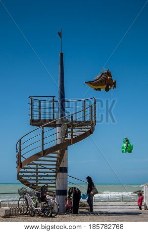 MARINA di CECINA ITALY - May 07 2017: Largo Cairoli during the Kite Festival and the flowers view of teh sea from the Terrace with spiral staircase