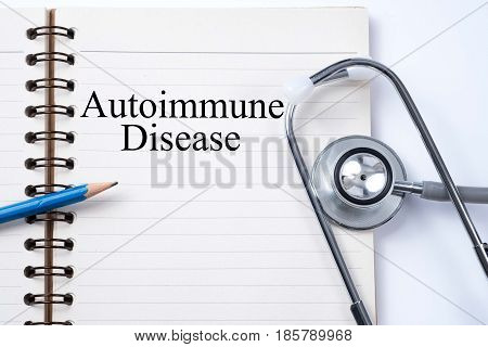 Stethoscope on notebook and pencil with Autoimmune Disease words as medical concept.
