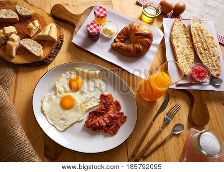 Continental breakfast croissant eggs bacon bread slices orange jiuce