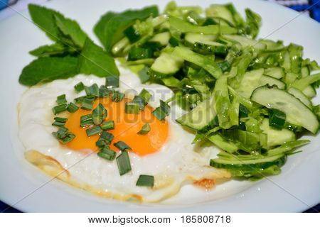 Appetizing scrambled eggs with cabbage salad on a white plate