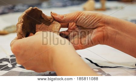 Female sculptor is modeling clay figurine or creating pottery ceramics statuette. Art and handicraft modelling creation.
